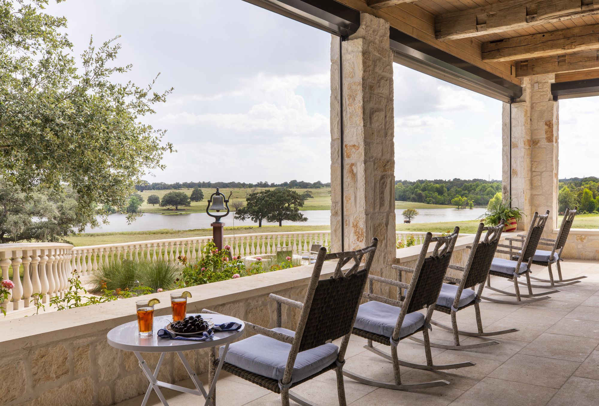 The covered porch at Texsix Ranch, rocking chairs looking out over the lake