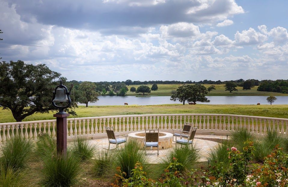 The terrace and ranch bell overlooking the lake and pasture